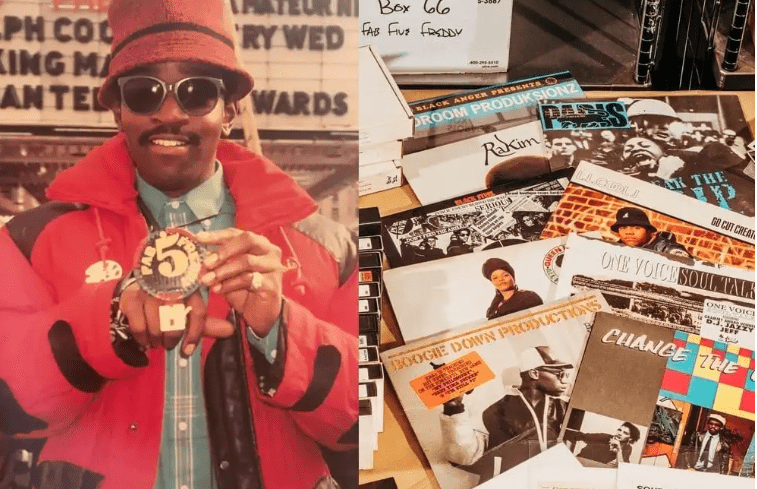 Fab 5 Freddy standing next to a collection of hip hop vinyl